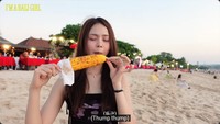 Carmen langsung menikmati jagung bakar yang dibumbui saus manis pedas. Ia mengungkapkan kalau rasanya sangat enak. Foto: YouTube Hearts2Hearts