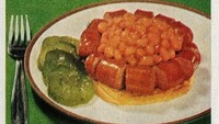 Resep Baked Bean Sausage Crown menyajikan roti yang dipenuhi potongan sosis panas yang disusun membentuk lingkaran, lalu ditumpuk olahan kacang panggang kental di bagian tengah. Meski dulunya dianggap praktis, kini tampilannya dinilai aneh. Foto: Bored Panda