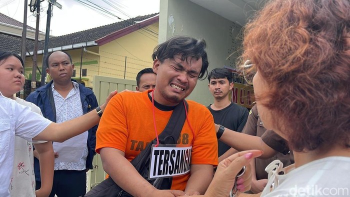 Eks sopir Khamozaro saat menangis sambil menyalami istri Khamozaro. (Finta Rahyuni/detikSumut)