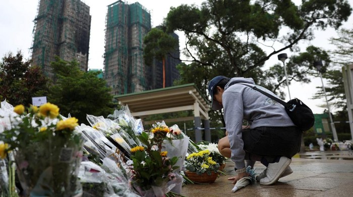 A person pays respect at a makeshift memorial with flower tributes for victims of the deadly fire on Wednesday, near the Wang Fuk Court housing complex in Tai Po, Hong Kong, China December 1, 2025. REUTERS/Amr Alfiky