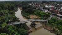 Sisa konstruksi jembatan yang ambruk tampak menjorok ke aliran sungai, menunjukkan titik patahan akibat erosi kuat. ANTARA FOTO/Muhammad Mada