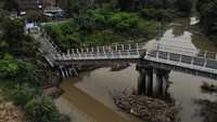 Foto udara memperlihatkan jembatan Kedungdowo di Nganjuk yang roboh usai tergerus arus sungai pada Senin (1/12/2025). Struktur sepanjang 60 meter itu kini terputus total dan tidak bisa dilintasi warga. ANTARA FOTO/Muhammad Mada