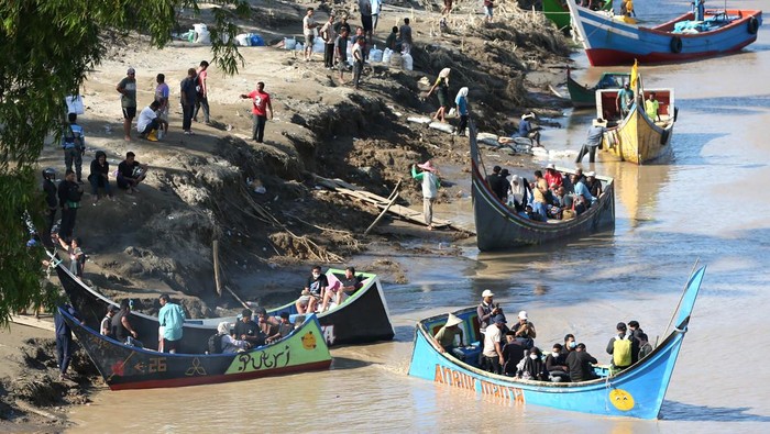 Warga menaiki tangga usai menyeberangi Sungai Tingkeum pascabencana banjir dan meluapnya sungai Tingkeum di Bireuen, Aceh, Senin (1/12/2025). Belasan perahu nelayan membantu warga menyeberangi sungai yang menghubungkan kabupaten Bireuen dan kabupaten Aceh Utara karena terputusnya jembatan Kuta Blang akibat banjir luapan sungai Tingkeum pada 26 November 2025. ANTARA FOTO/Irwansyah Putra