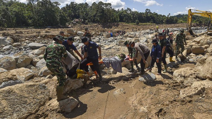 Prajurit TNI dan anggota kepolisian mengevakuasi korban sakit dari desa terisolir akibat banjir bandang di Nagari Salareh Aia Timur, Palembayan, Agam, Sumatera Barat, Senin (1/12/2025). Banjir bandang yang terjadi pada Kamis (27/11) di daerah itu mengakibatkan beberapa akses jalan menuju permukiman putus sehingga menyulitkan akses jalan warga menuju pasar dan tempat-tempat layanan kesehatan. ANTARA FOTO/Wahdi Septiawan