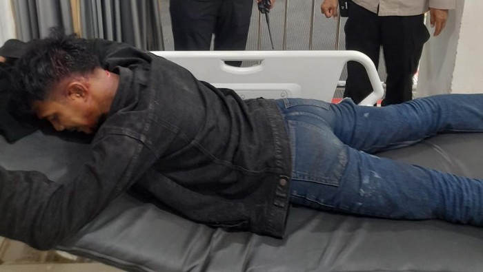 Polisi membawa korban pembacokan ke rumah sakit.