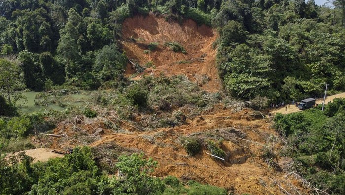 Foto udara warga melintasi material longsor berupa tanah, batu dan pohon yang menutupi jalan lintas antar Kabupaten Aceh Utara dan Kabupaten Bener Meriah di kecamatan Nisam Antara, Aceh Utara, Aceh, Minggu (30/11/2025). Jalan lintas yang meghubungkan Kabupaten Aceh Utara dan Kabupaten Bener Meriah tersebut putus tertutup material longsor sejak Selasa (25/11). ANTARA FOTO/Abiyyu/Lmo/nz