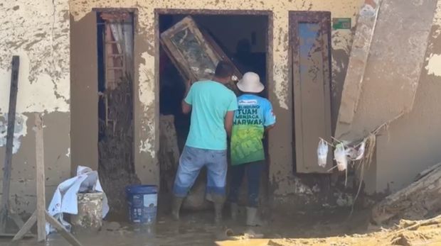 Personel BKO Polda Riau membantu warga mengeruk lumpur pascabanjir bandang di Nagari Salareh Air, Kabupaten Agam, Sumbar, Senin (1/12/2025).