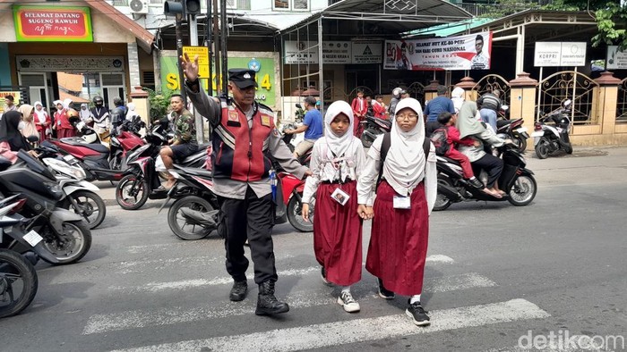 Polisi di Sidoarjo menyeberangkan siswa