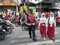 Aksi Polisi Sidoarjo Atur Lalu Lintas-Bantu Pelajar Menyeberang Jalan