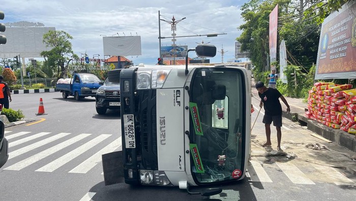 Truk pengangkut semen oleng akibat kelebihan muatan di Bypass Nusa Dua, Badung. Senin (1/12/2025).