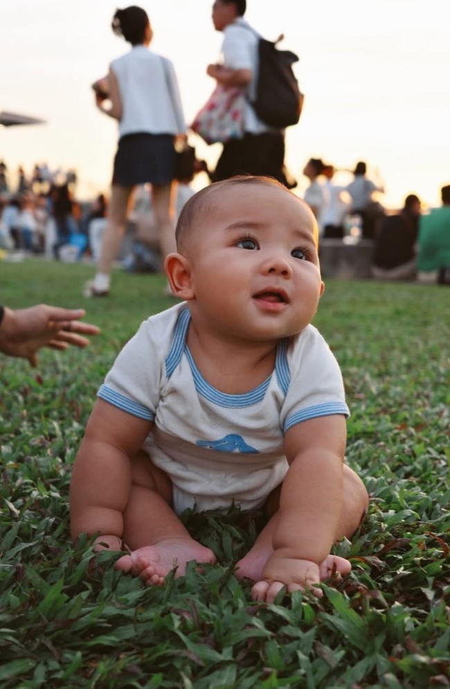 Terlihat baby Arash ikut menikmati liburannya dengan berpiknik di atas rumput bersama mama dan papa. Duduk langsung di atas rumput, baby Arash tampak nyaman sambil mengasah kemampuan sensoriknya. Foto: Instagram/@aaliyah.massaid
