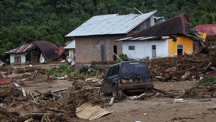 A car stuck in the mud sits among debris at an area hit by deadly flash floods following heavy rains in Palembayan, Agam regency, West Sumatra province, Indonesia, December 2, 2025. REUTERS/Willy Kurniawan