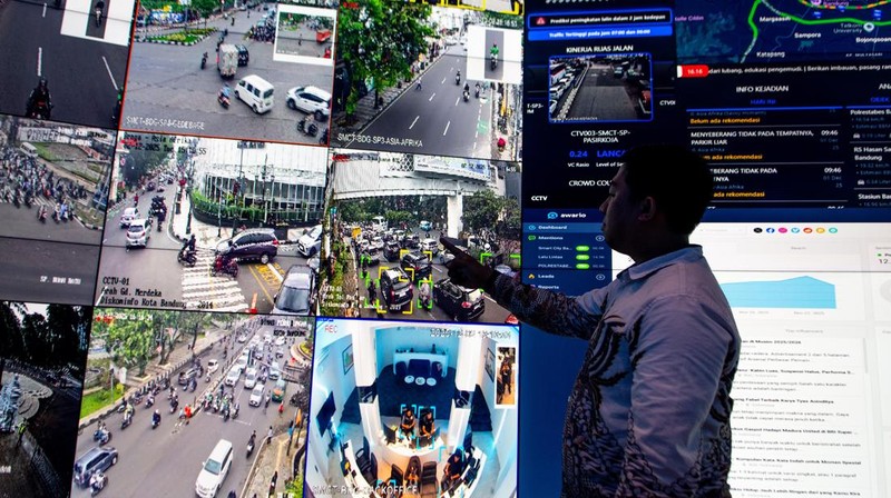 Personel kepolisian menunjuk kondisi lalu lintas melalui layar di pelayanan Smart Road Safety Policing di Polrestabes Bandung, Jawa Barat, Selasa (2/12/2025).  Korps Lalu Lintas (Korlantas) Polri menghadirkan program Smart Road Safety Policing di Polrestabes Bandung dengan memasang 200 kamera pengawas atau CCTV sebagai sistem manajemen lalu lintas berbasis kecerdasan buatan (artificial intelligence/AI) untuk melakukan penanganan kepadatan lalu lintas, serta telah terintegrasi layanan darurat 110 sebagai inovasi transformasi digital pelayanan publik Polri. ANTARA FOTO/Novrian Arbi