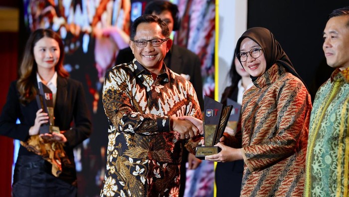 Bupati Banyuwangi Ipuk Fiestiandani saat menerima penghargaan dari Mendagri Tito Karnavian.