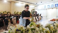 Seorang pria meletakkan bunga putih untuk mengenang para korban. Karangan bunga terus berdatangan dari warga yang ingin menyampaikan belasungkawa. Foto: REUTERS/Lam Yik
