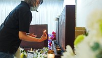 Seorang wanita menyalakan lilin sebagai bentuk doa bagi para korban tragedi Wang Fuk Court. Cahaya lilin menjadi simbol harapan dan penghormatan terakhir. Foto: REUTERS/Lam Yik