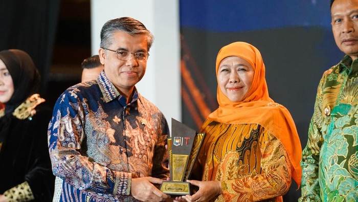 Gubernur Jatim Khofifah Indar Parawansa menerima tropi penghargaan atas serapan tenaga kerja dengan fiskal tinggi.