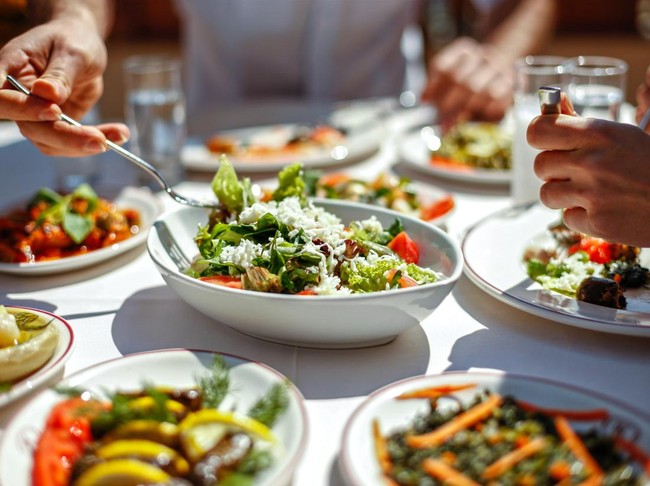 Couple  Eating Lunch with Fresh Salad and Appetizers
