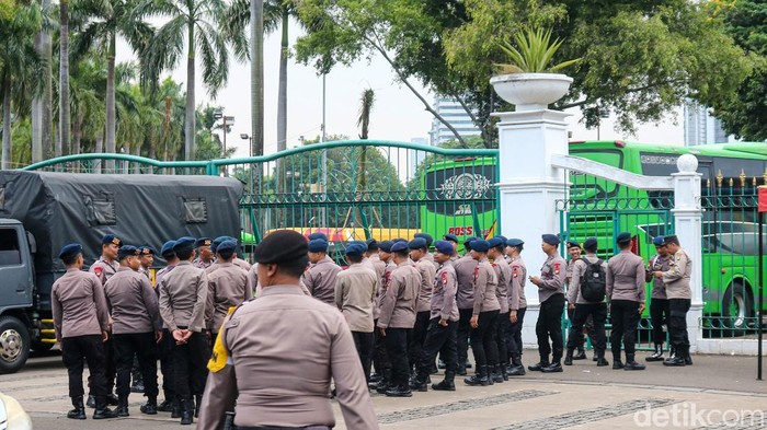 Sejumlah aparat tampak berbaris dalam persiapan di kawasan Monas, Jakarta Pusat, Selasa (2/12/2025). Selain aparat keamanan, relawan ambulans terlihat bersiaga untuk memberikan penanganan medis bila diperlukan.