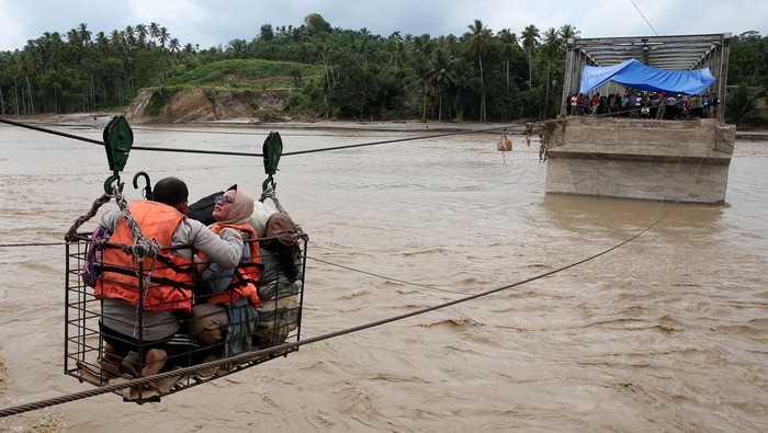 Warga menggunakan kabel baja yang untuk menyeberangi Sungai Juli pascaputusnya Jembatan Juli di jalan lintas Bireuen - Takengon, Aceh, Selasa (2/12/2025). Kabel baja yang didesain khusus relawan bencana menjadi sarana penghubung untuk memobilisasi warga dan barang sejak putusnya jembatan Juli pada 26 November 2025 akibat banjir luapan Sungai Peusangan. ANTARA FOTO/Irwansyah Putra