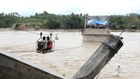 Meski sederhana dan berisiko, kabel baja menjadi satu-satunya akses bagi masyarakat yang terisolasi akibat putusnya jembatan. ANTARA FOTO/Irwansyah Putra