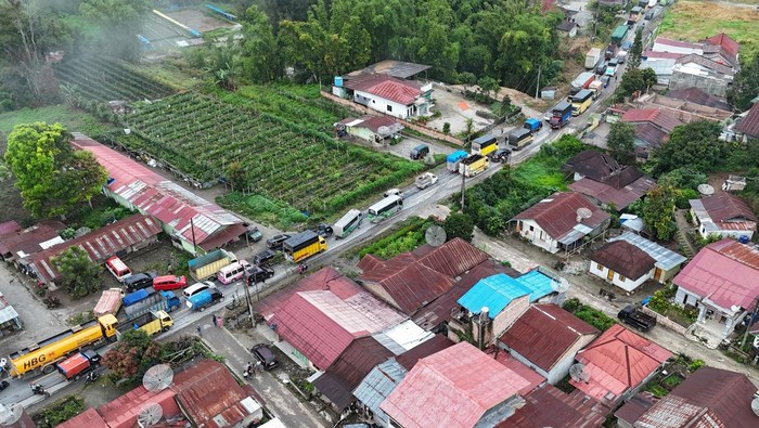 Foto udara terlihat antrean panjang kendaraan untuk mengisi Bahan Bakar Minyak (BBM) di salah satu SPBU di Kabupaten Karo, Sumatera Utara, Selasa (2/12/2025). Kemacetan akibat antrean kendaraan sepanjang dua hingga lima kilometer terlihat di sejumlah SPBU di Kabupaten Karo diduga akibat beli panik (panic buying) BBM dampak bencana banjir dan tanah longsor. ANTARA FOTO/Syifa Yulinnas/foc.