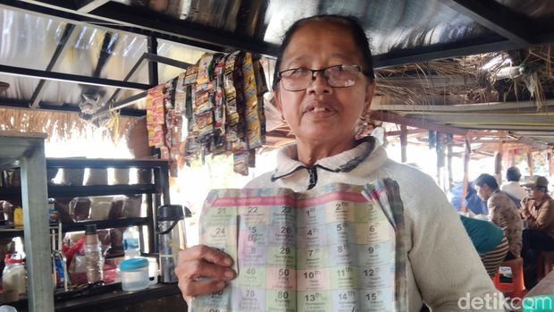 Mbah Anik atau Ni Wayan Suarni saat melayani tamu asing di depan lapaknya di DTW Jatiluwih, Kecamatan Penebel, Tabanan, dengan masih menggunakan kamus.