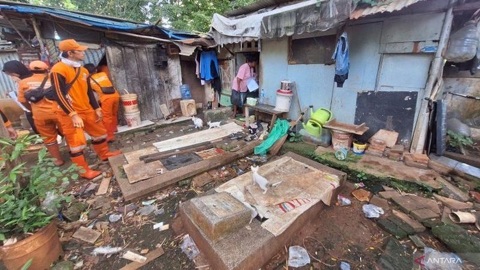 Petugas gabungan membantu relokasi warga di tempat pemakaman umum (TPU) Menteng Pulo 2, Tebet, Jakarta, Selasa (2/12/2025). ANTARA/Luthfia Miranda Putri.