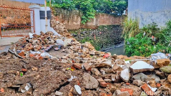 Tembok jebol akibat diterjang banjir.