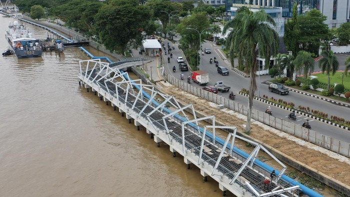 Foto udara pekerja menyelesaikan pembangunan Teras Samarinda tahap kedua di tepian sungai Mahakam, Samarinda, Kalimantan Timur, Selasa (2/12/2025). Pemkot Samarinda mengalokasikan anggaran dari dana APBD 2025 sebesar Rp94,34 miliar untuk pembangunan Teras Samarinda tahap kedua yang dibagi dalam empat segmen dengan fokus pada penataan ruang publik untuk pejalan kaki, penambahan area hijau, pembangunan infrastruktur pengendali banjir, serta penataan jalur transportasi umum. ANTARA FOTO/M Risyal Hidayat/bar