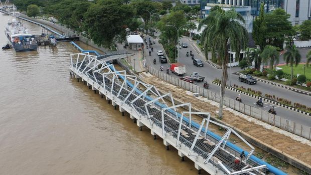 Foto udara pekerja menyelesaikan pembangunan Teras Samarinda tahap kedua di tepian sungai Mahakam, Samarinda, Kalimantan Timur, Selasa (2/12/2025). Pemkot Samarinda mengalokasikan anggaran dari dana APBD 2025 sebesar Rp94,34 miliar untuk pembangunan Teras Samarinda tahap kedua yang dibagi dalam empat segmen dengan fokus pada penataan ruang publik untuk pejalan kaki, penambahan area hijau, pembangunan infrastruktur pengendali banjir, serta penataan jalur transportasi umum. ANTARA FOTO/M Risyal Hidayat/bar