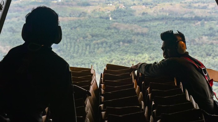 Sejumlah helibox di distribusikan Prajurit TNI AU Skadron Udara 2  menggunakan metode Container Delivery Sistem (CDS) dengan pesawat CN 295 di Kecamatan Kuala Simpang, Kabupaten Aceh Tamiang, Aceh, Selasa (2/12/2025). TNI AU mendistribusikan 90 heli box bantuan berisi makanan untuk pengungsi bencana di wilayah Kabupaten Aceh Tamiang yang terisolir akibat bencana banjir. ANTARA FOTO/Fakhri Hermansyah