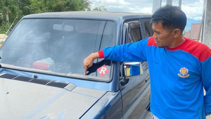 Warga di Kecamatan Canduang, Kabupaten Agam menunjuk tumpukan abu vulkanik yang jatuh ke mobil usai erupsi Gunung Marapi pada Selasa (2/12) (Antara/AL Fatah)