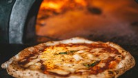 Pizza Napoletana menghadirkan rasa pizza sederhana hanya dengan saus tomat, bawang putih, oregano, mozarella dan topping lain. Walaupun begitu keaslian rasanya justru jadi kebangganan Italia. Foto: Taste Atlas