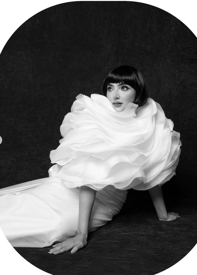 Bagian bawah gaun hadir dalam potongan panjang lurus yang simpel, membuatnya tampak seimbang dengan ruffles besar di bagian atas. Warna putih memberi kesan bersih dan futuristik. Foto: Instagram/@mozawahyu