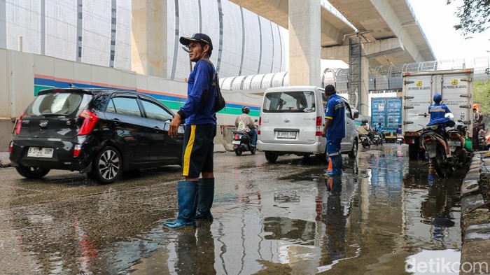 Petugas SDA melakukan penyedotan air di Jl RE Martadinata, Jakarta Utara, Rabu (3/12/2025), untuk mempercepat surutnya banjir rob yang menghambat pergerakan kendaraan.