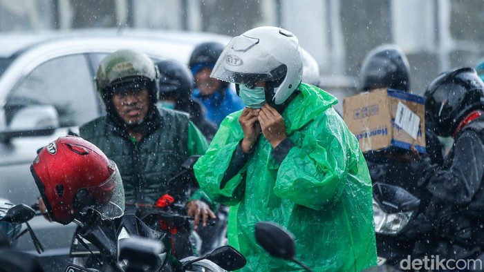 Pengendara menggunakan jas hujan di kolong jembatan penyeberangan di Jakarta, Rabu (3/12/2025). Badan Meteorologi, Klimatologi, dan Geofisika (BMKG) mengimbau seluruh masyarakat Indonesia untuk meningkatkan kewaspadaan terhadap potensi hujan dengan sedang hingga lebat seiring dengan masuknya sebagian besar wilayah Indonesia ke puncak musim hujan.