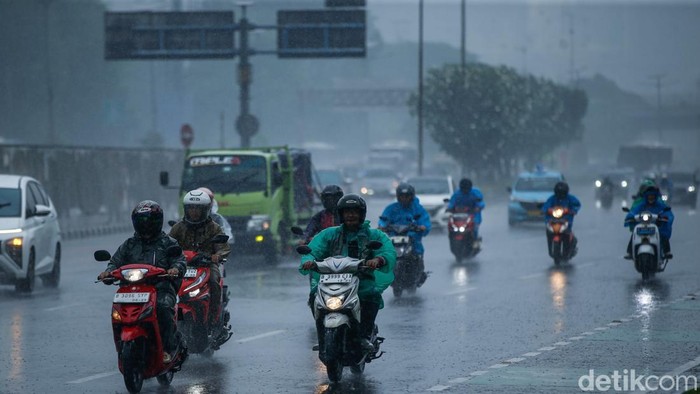 Pengendara menggunakan jas hujan di kolong jembatan penyeberangan di Jakarta, Rabu (3/12/2025). Badan Meteorologi, Klimatologi, dan Geofisika (BMKG) mengimbau seluruh masyarakat Indonesia untuk meningkatkan kewaspadaan terhadap potensi hujan dengan sedang hingga lebat seiring dengan masuknya sebagian besar wilayah Indonesia ke puncak musim hujan.