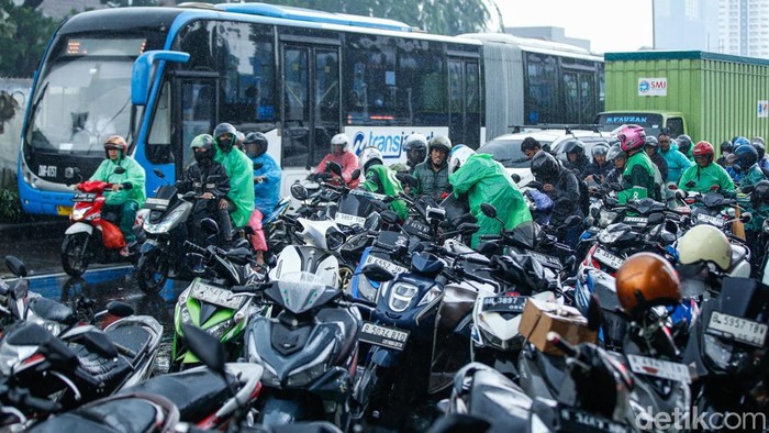 Pengendara menggunakan jas hujan di kolong jembatan penyeberangan di Jakarta, Rabu (3/12/2025). Badan Meteorologi, Klimatologi, dan Geofisika (BMKG) mengimbau seluruh masyarakat Indonesia untuk meningkatkan kewaspadaan terhadap potensi hujan dengan sedang hingga lebat seiring dengan masuknya sebagian besar wilayah Indonesia ke puncak musim hujan.