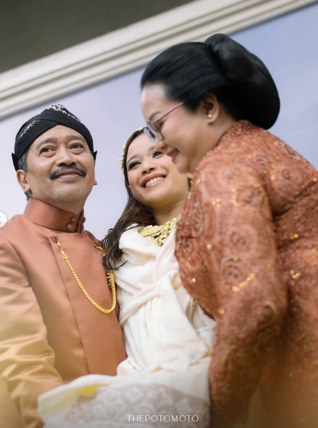 Kedua orangtua Jodie tampil serasi kenakan beskap dan kebaya berwarna terakota. Dengan kompak mereka tampak menggendong Jodie setelah prosesi siraman. Foto: Instagram/@brisiajodie96