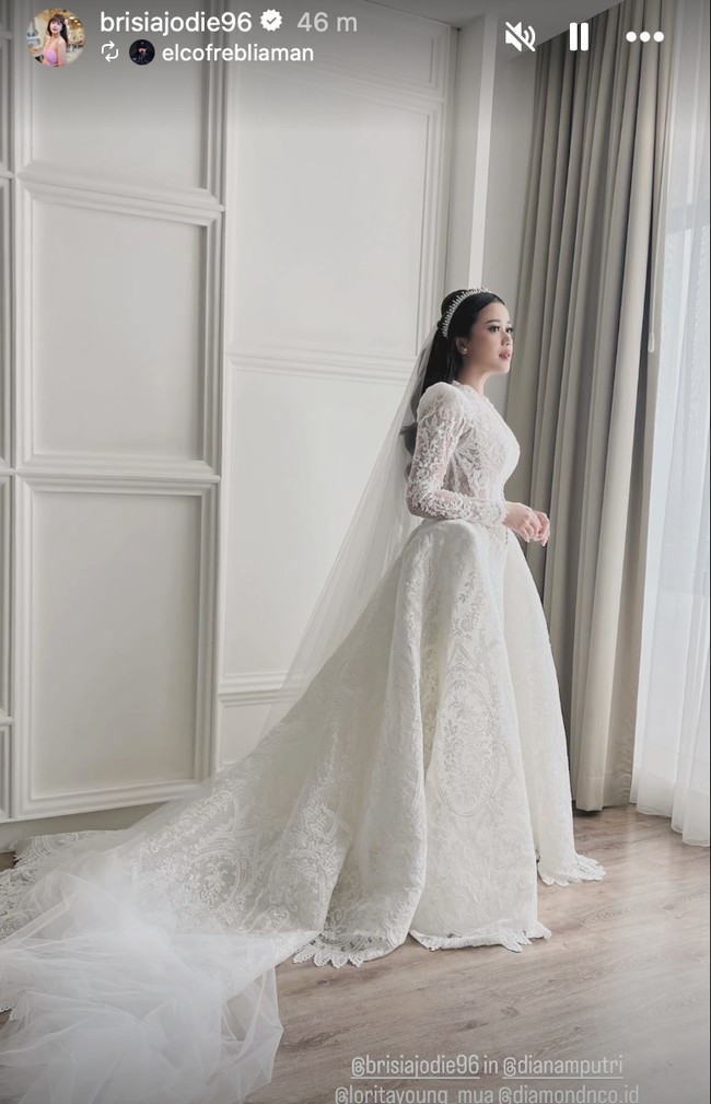 Rancangan DIANA COUTURE by Diana M Putri, gaun pengantin bernuansas klasik itu tampak mewah dengan silueeet A-line dan train panjang. Bagian atas gaun menggunakan lace yang lebih tipis sehingga tampak semi-transparan pada lengan. Foto: Instagram/@brisiajodie96