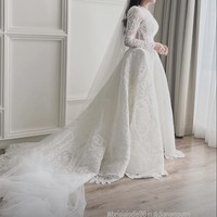 Rancangan DIANA COUTURE by Diana M Putri, gaun pengantin bernuansas klasik itu tampak mewah dengan silueeet A-line dan train panjang. Bagian atas gaun menggunakan lace yang lebih tipis sehingga tampak semi-transparan pada lengan. Foto: Instagram/@brisiajodie96