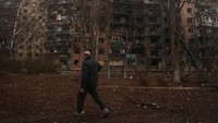Seorang warga berjalan di dekat gedung apartemen yang telah rusak akibat serangan drone Rusia, yang terjadi pada Senin malam, di tengah serangan Rusia terhadap Ukraina, di kota Kramatorsk, wilayah Donetsk, Ukraina, Selasa (2/12/2025). REUTERS/Anatolii Stepanov