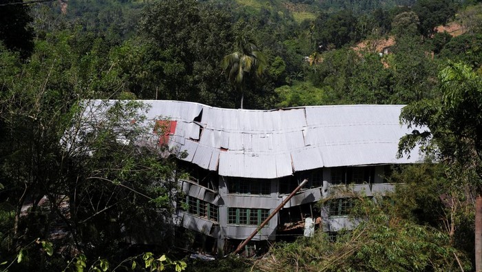 A man holds up a food packet as he moves through mud after landslides triggered by heavy rainfall following Cyclone Ditwah, in Mawathura in Kandy district, Sri Lanka, December 3, 2025. REUTERS/Thilina Kaluthotage