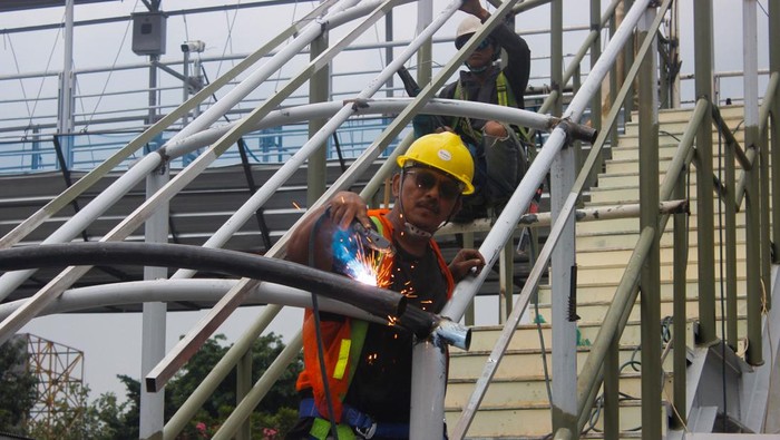 Pengerjaan revitalisasi Jembatan Penyeberangan Orang (JPO) di Halte Gelanggang Remaja Otista, Jakarta Timur, terus menunjukkan perkembangan signifikan. Pada Rabu (3/12/2025), aktivitas para pekerja tampak semakin intens di lokasi, menandai progres konstruksi yang kini memasuki tahap penyelesaian struktur utama.