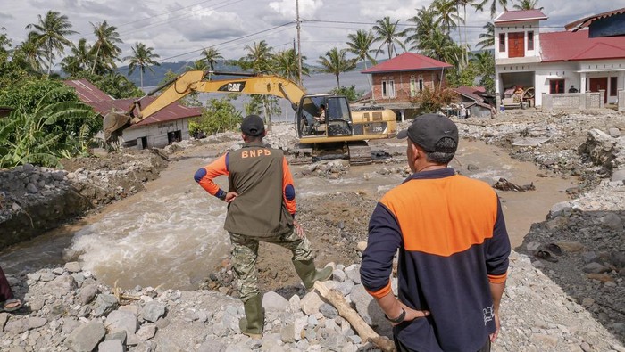 Pekerja mengoperasikan alat berat saat membersihkan material banjir bandang dan tanah longsor di Nagari Guguak Malalo, Kabupaten Tanah Datar, Sumatera Barat, Selasa (2/12/2025). Akses menuju Nagari Padang Laweh dan Guguak Malalo sempat terputus dari wilayah sekitar, sehingga proses evakuasi warga dilakukan melalui jalur Danau Singkarak. ANTARA FOTO/Wawan Kurniawan/Lmo/bar