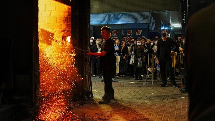 People burn offerings at Kowloon Funeral Parlour for victims of the deadly fire at the Wang Fuk Court housing complex in Tai Po, in Hong Kong, China, December 2, 2025. REUTERS/Lam Yik     TPX IMAGES OF THE DAY