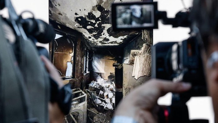 Journalists film a image taken inside burned apartments of Wang Fuk Court housing complex during a news conference following a deadly fire, in Tai Po, Hong Kong, China, December 1, 2025. REUTERS/Maxim Shemetov