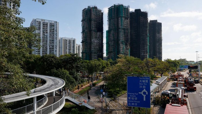 People walk near the buildings of the Wang Fuk Court housing complex after the deadly fire, in Tai Po, Hong Kong, China, December 2, 2025. REUTERS/Maxim Shemetov