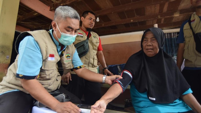 Petugas kesehatan memeriksa kondisi warga korban banjir bandang di Batu Busuk, Pauh, Padang, Sumatera Barat, Rabu (3/12/2025). Puskesmas Pauh bersama tim medis dari Jawa Tengah melakukan pemeriksaaan kesehatan bagi korban banjir bandang di rumah mereka, khususnya bagi anak-anak dan lansia serta menyalurkan bantuan biskuit PMT dari Kemenkes untuk balita. ANTARA FOTO/Iggoy el Fitra